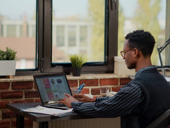 Financial consultant using laptop to work on business growth, analyzing sales management for experience. Male secretary planning innovation and development with commercial data.